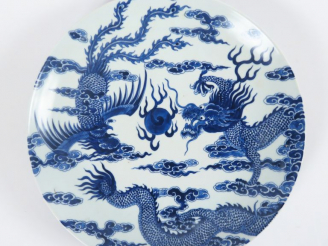 Vente aux enchères Plat en porcelaine, à décor de phenix et de dragon poursuivant la perl