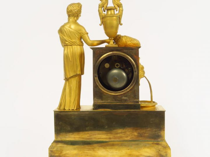 Pendule Restauration en bronze doré à décor de jeune fille, de brebis 