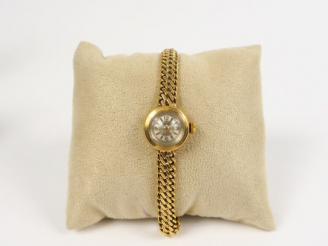Vente aux enchères Montre de dame bracelet souple et boitier en or jaune. Cadran signé Ge