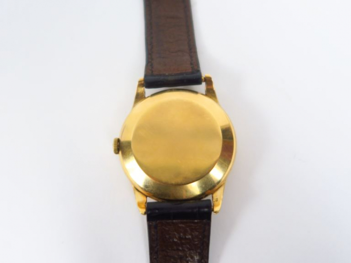 OMEGA.  Montre d'homme, boitier or, bracelet cuir.