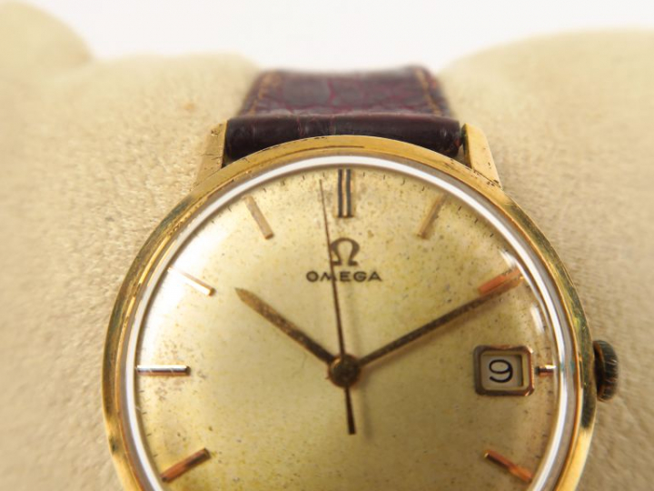 OMEGA. Montre  boitier or, guichet date. Diam. 35 mm  (cadran à nettoy