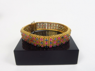 Vente aux enchères Bracelet articulé en or jaune orné de saphirs et de rubis.  Long. 18 c