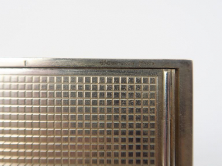 BOUCHERON.  Poudrier en argent et or rehaussé de sept rubis, à décor a