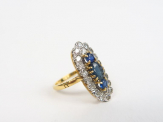 Vente aux enchères Bague marquise en or ornée de trois saphirs et entourage de petits bri