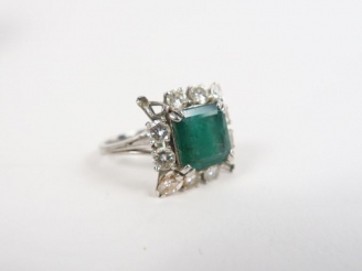 Vente aux enchères Bague en or blanc ornée d'une émeraude entourée de diamants.  TDD. 55 