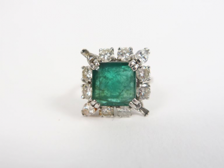 Bague en or blanc ornée d'une émeraude entourée de diamants.  TDD. 55 
