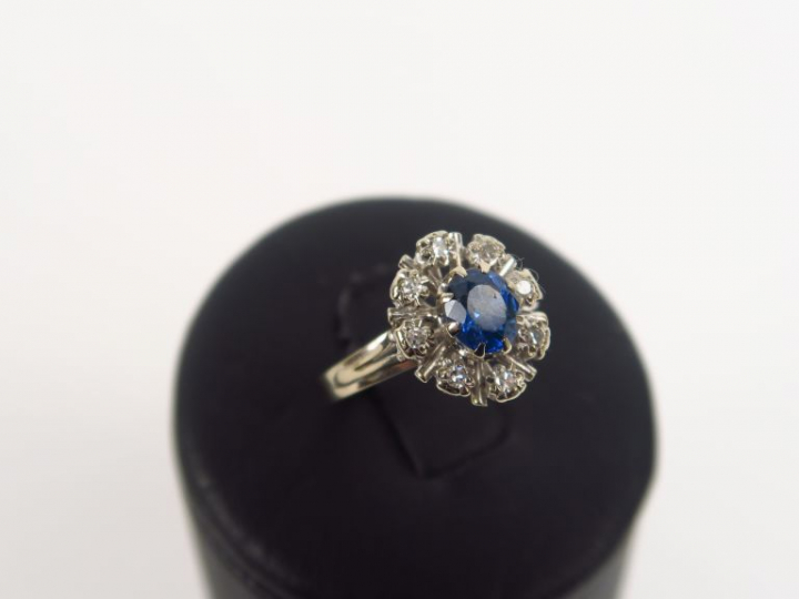 Bague marguerite monture or blanc, ornée d'un saphir entouré de huit b