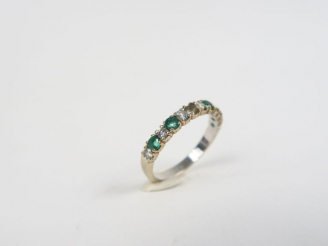 Vente aux enchères Demi-alliance en or gris, brillants et émeraudes. Poids. 2 g (une émer