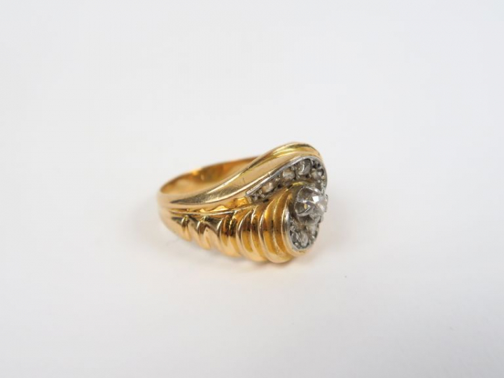 Bague en or jaune torsadée, diamant central entouré de roses. Poids : 