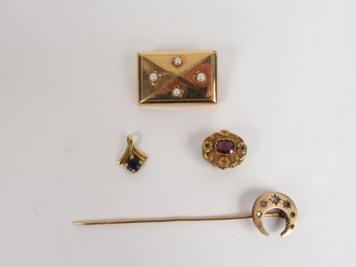 Lot comprenant une broche, deux différents pendentifs et une épingle à