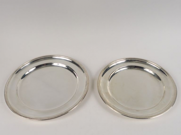 ORBRILLE. Deux plats ronds en métal argenté, à décor de rang de perles