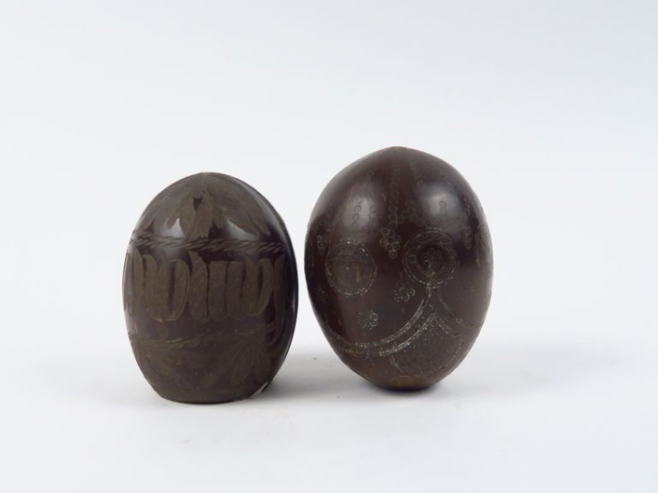 Deux différentes noix de coco, à décor gravé. H. 11 cm et 12 cm