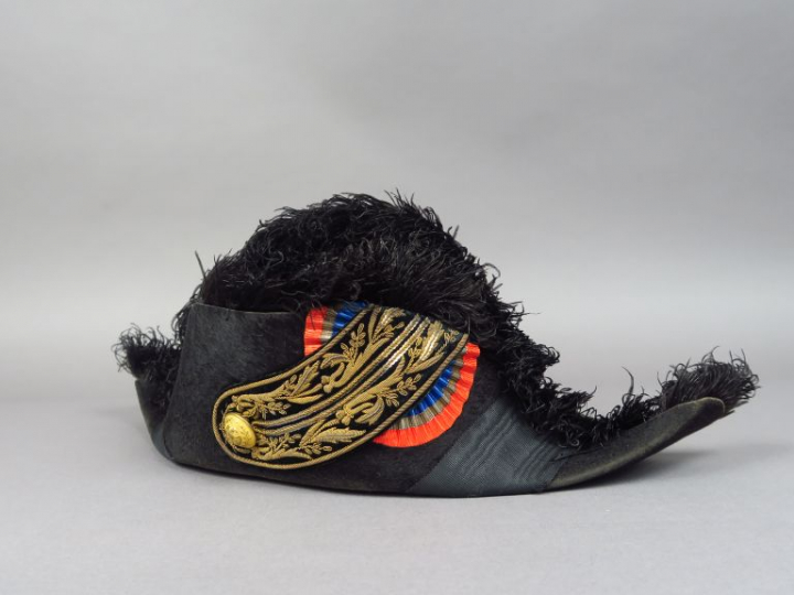 Bicorne en taupé noir, bordure en plume d'autruche noire, bouton doré 