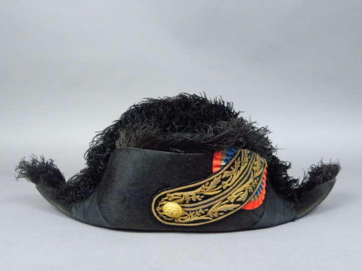 Bicorne en taupé noir, bordure en plume d'autruche noire, bouton doré 