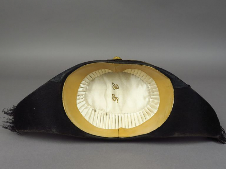 Bicorne en taupé noir, bordure en plume d'autruche noire, bouton doré 