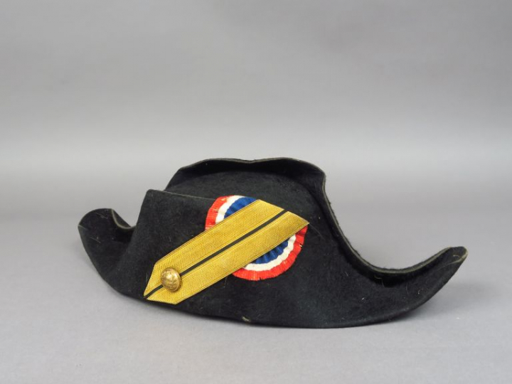 Bicorne en taupé noir, sans galon, bouton à décor de couronne de lauri