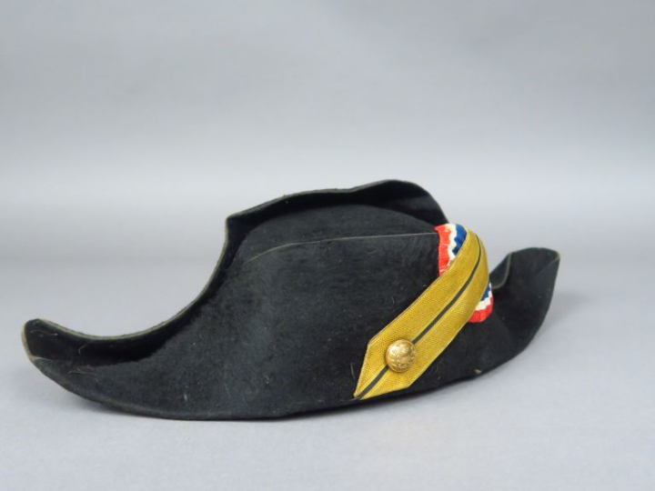 Bicorne en taupé noir, sans galon, bouton à décor de couronne de lauri