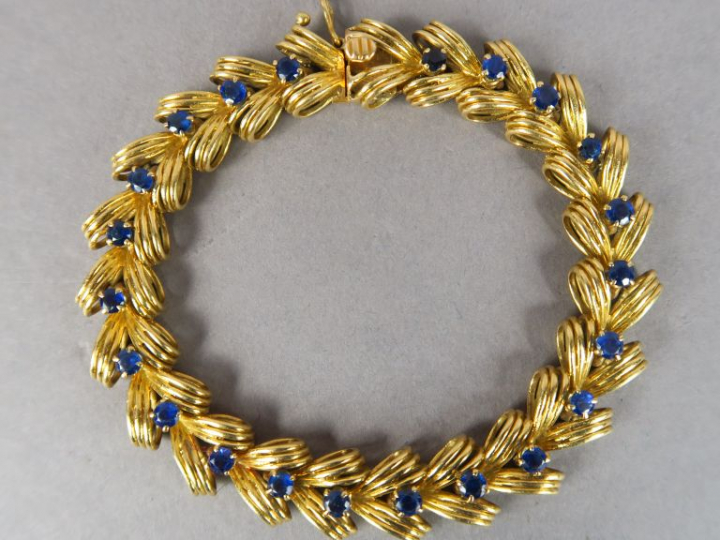 BOUCHERON.  Bracelet articulé en or jaune et vingt-deux saphirs. Signé
