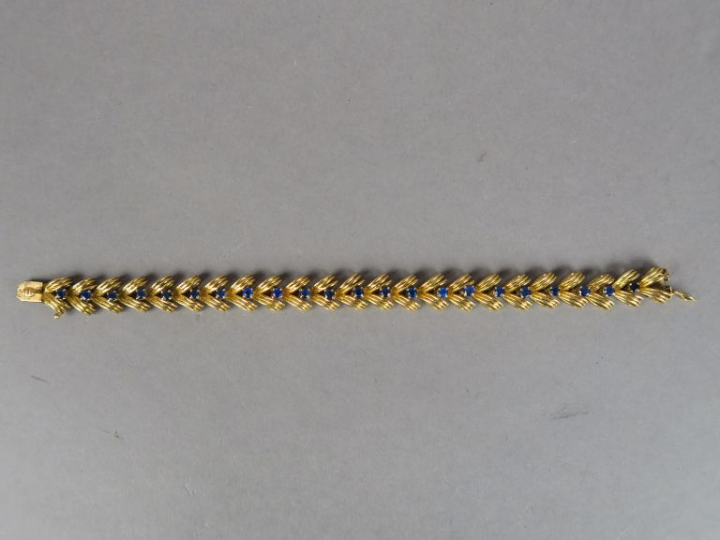 BOUCHERON.  Bracelet articulé en or jaune et vingt-deux saphirs. Signé