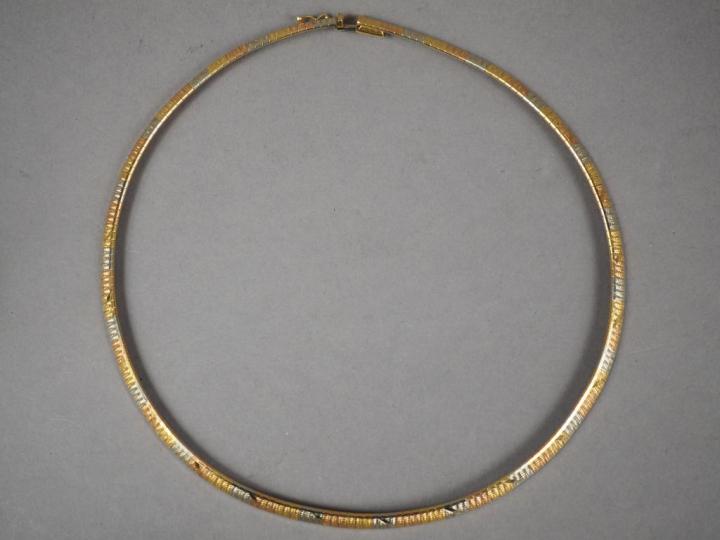 Collier articulé trois ors, à décor de motifs géométriques.  Poids. 36