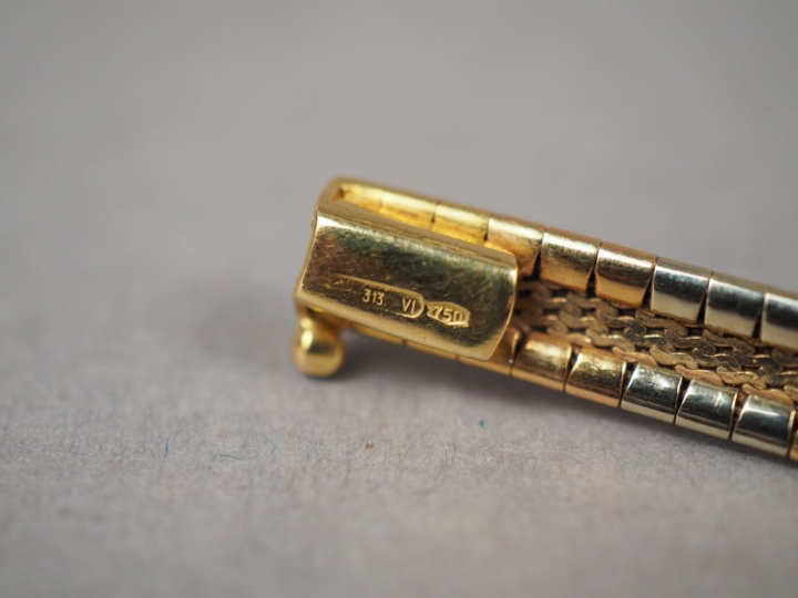 Collier articulé trois ors, à décor de motifs géométriques.  Poids. 36