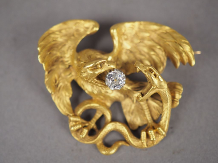 Broche en or jaune figurant un aigle et un serpent se battant. L'aigle