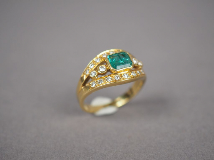 Bague en or jaune, ornée d'une émeraude et de petits diamants.  TDD. 5