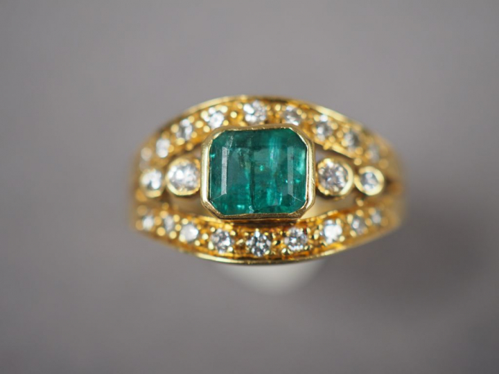 Bague en or jaune, ornée d'une émeraude et de petits diamants.  TDD. 5