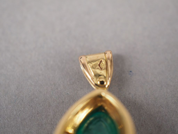 Pendentif en or jaune, orné d'une émeraude en cabochon et de neuf peti