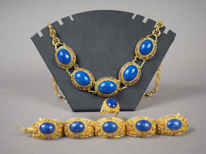 Parure en métal doré, émail et lapis lazuli en cabochon. Comprenant : 