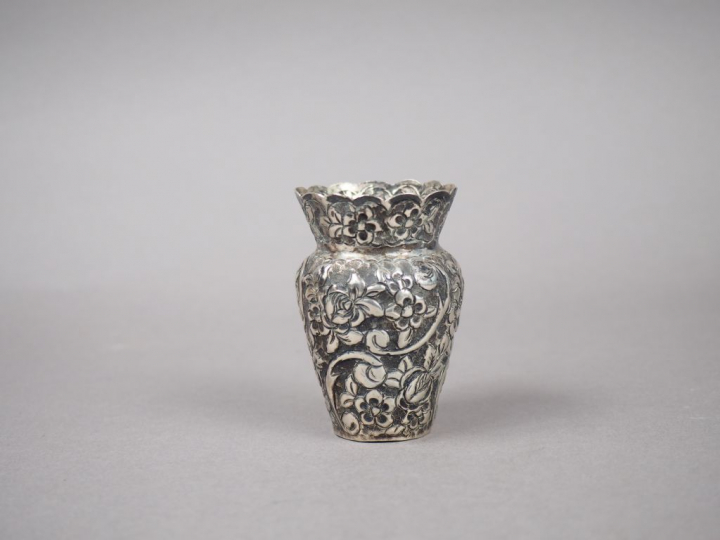 Petit vase en argent 800 millièmes, à décor au repoussé de fleurs.  H.