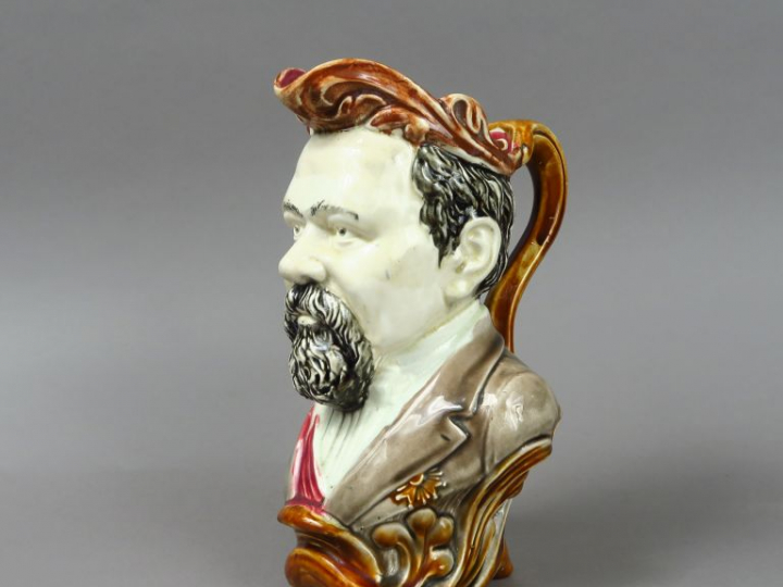 Pichet trompeur XIXe en barbotine en forme d'homme barbu. H. : 27,5 cm