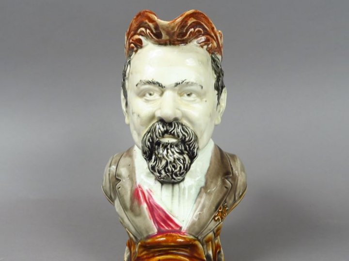 Pichet trompeur XIXe en barbotine en forme d'homme barbu. H. : 27,5 cm