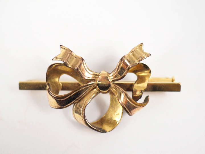Broche en or jaune, à décor d'un nœud de ruban.  Poids. 3,42 g (accide