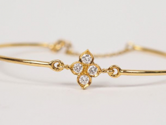 Vente aux enchères 	CARTIER.  Bracelet jonc en or jaune et diamants.  Signé. Numéroté D90