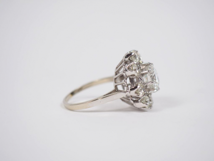 Bague marguerite en or blanc, sertie d'un diamant central taille brill