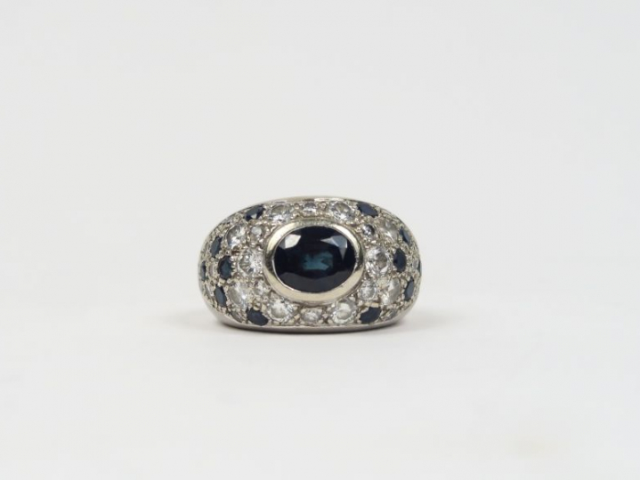 Bague dôme en or blanc, ornée en son centre d'un saphir entouré de pet