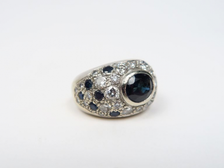 Bague dôme en or blanc, ornée en son centre d'un saphir entouré de pet