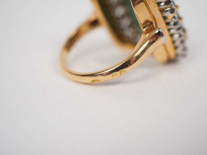 Bague en or jaune et platine, ornée en son centre d'une émeraude entou