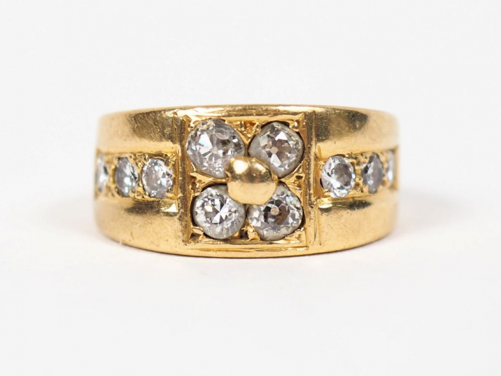 	Bague jonc en or jaune ornée de dix diamants, à décor de fleur. TDD. 