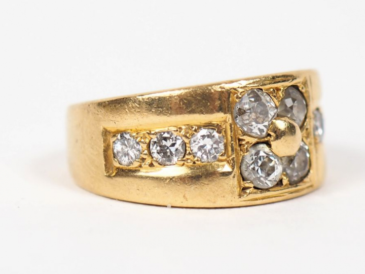 	Bague jonc en or jaune ornée de dix diamants, à décor de fleur. TDD. 
