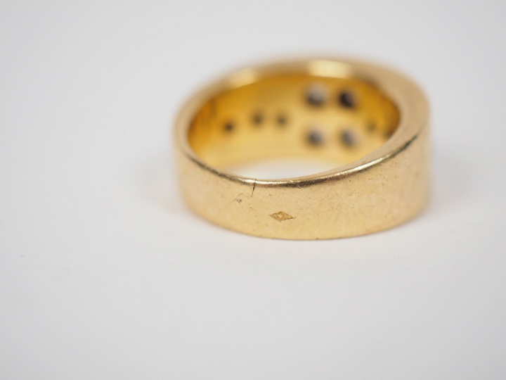 	Bague jonc en or jaune ornée de dix diamants, à décor de fleur. TDD. 