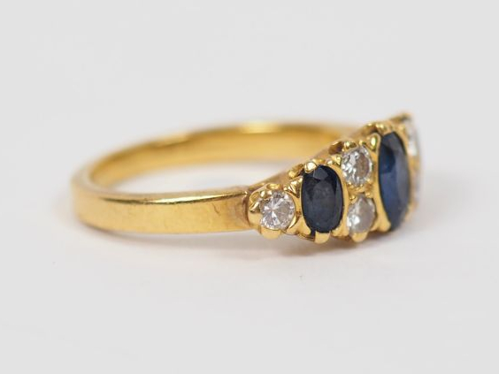 Bague en or jaune, ornée de trois saphirs entourés de six petits diama