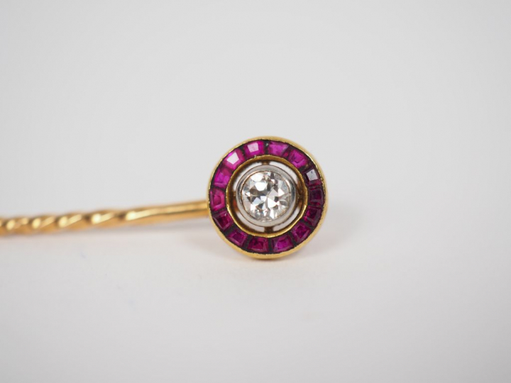 Une épingle de cravate en or, diamant et rubis calibrés. Poids tel. 2,
