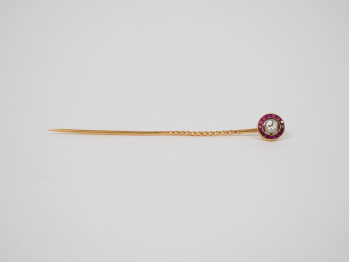 Une épingle de cravate en or, diamant et rubis calibrés. Poids tel. 2,