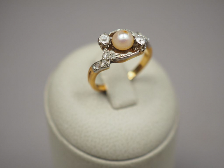 Bague en or jaune, ornée d'une perle entourée de diamant et de roses. 