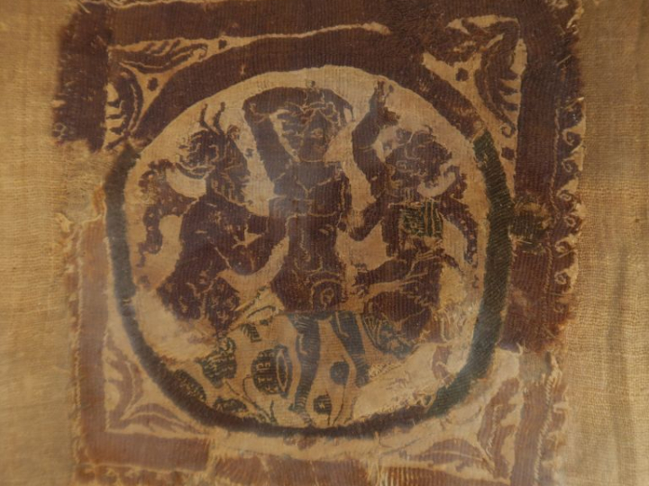 Fragment de tissu Copte ancien représentant trois danseurs dans un méd