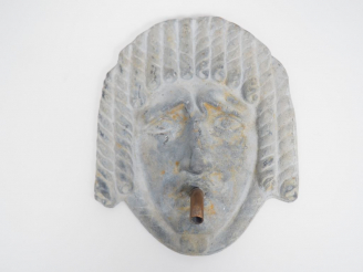 Vente aux enchères Elément de fontaine en plomb en forme de masque. H. : 16,5 cm.