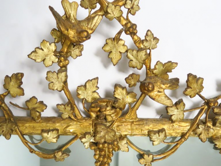 Glace fin XIXème en bois et stuc doré, à décor de pampres et d'oiseaux