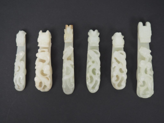 Vente aux enchères Ensemble de six fibules en jade blanc céladon décor de double dragon. 
